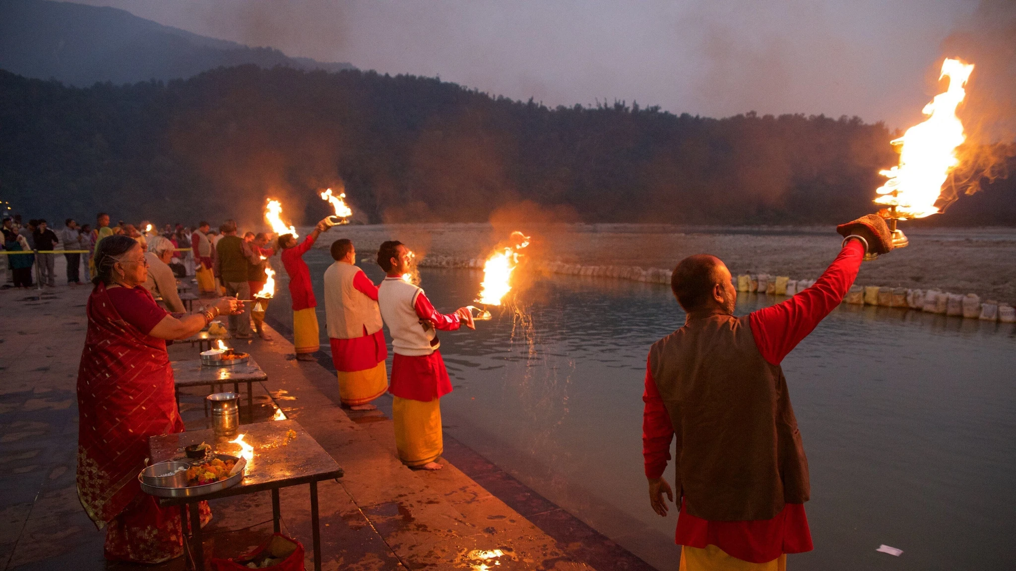 Scenic view of Haridwar's ghats and temples along the Ganges River, with people performing aarti.