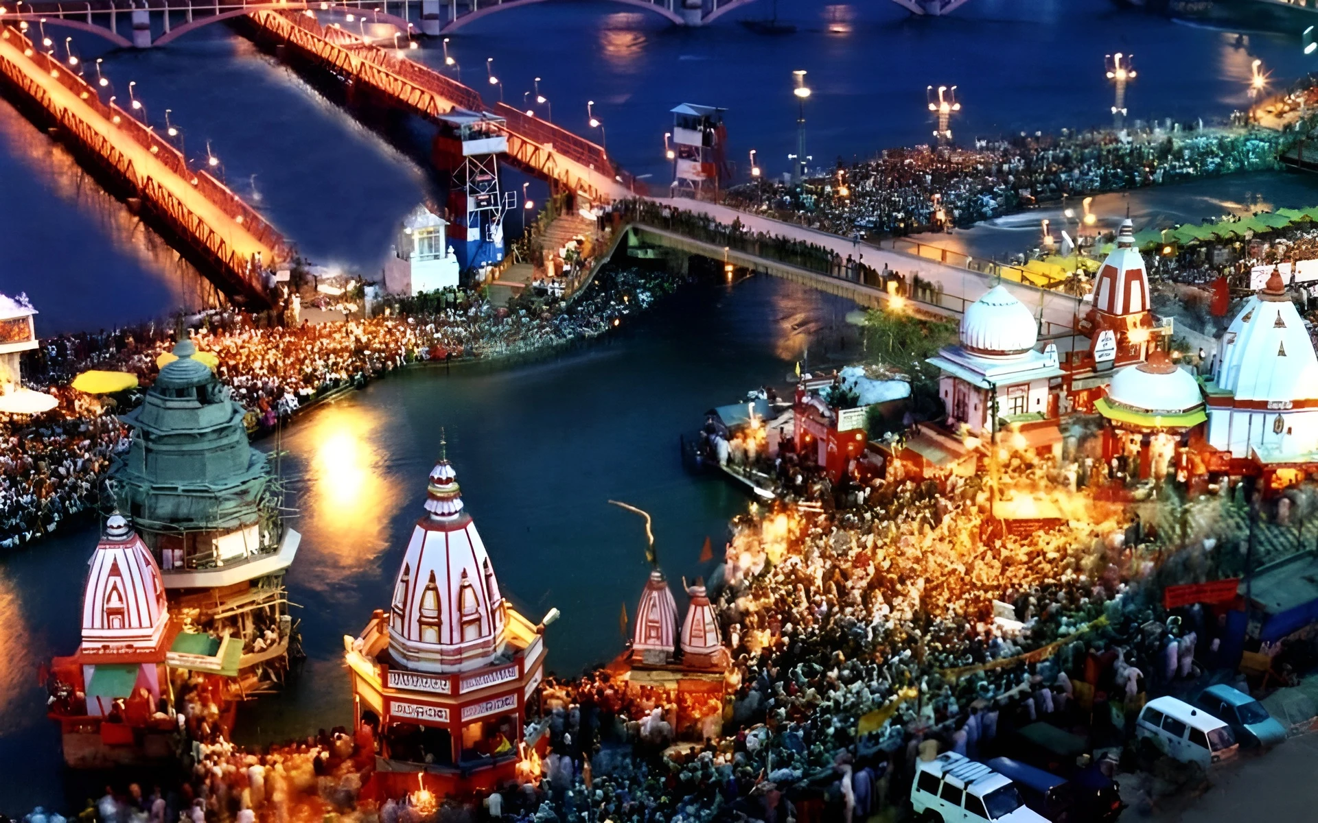 Scenic view of Haridwar's ghats and temples along the Ganges River, with people performing aarti.